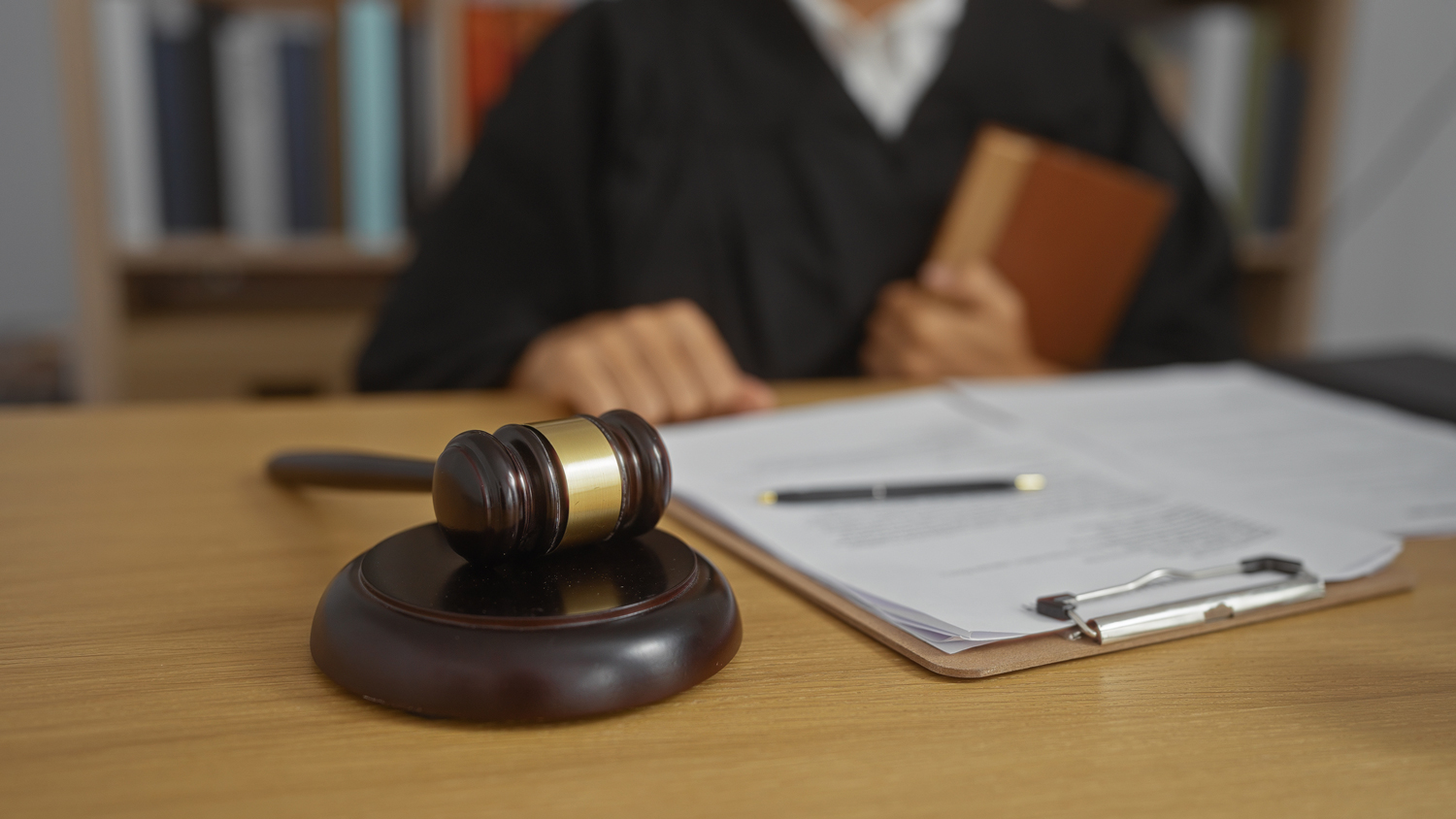 Judge in courtroom with gavel and documents on desk